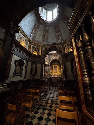 A domed chapel with a checkered floor is inside the Sablon church in Brussels.