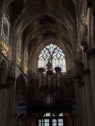 The organ stands below a stained glass window in the Sablon church in Brussels.