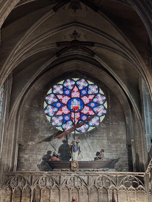 A round rose window shines above a boat sculpture in the Sablon church in Brussels.