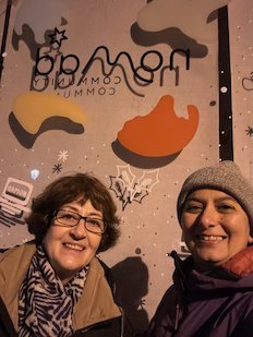 Zayera Khan and a friend smile in a selfie in front of a wall in Brussels.