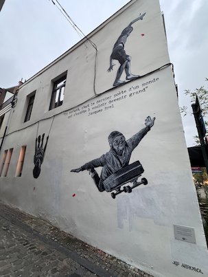 A black and white mural of skaters covers the side of a house in Brussels.