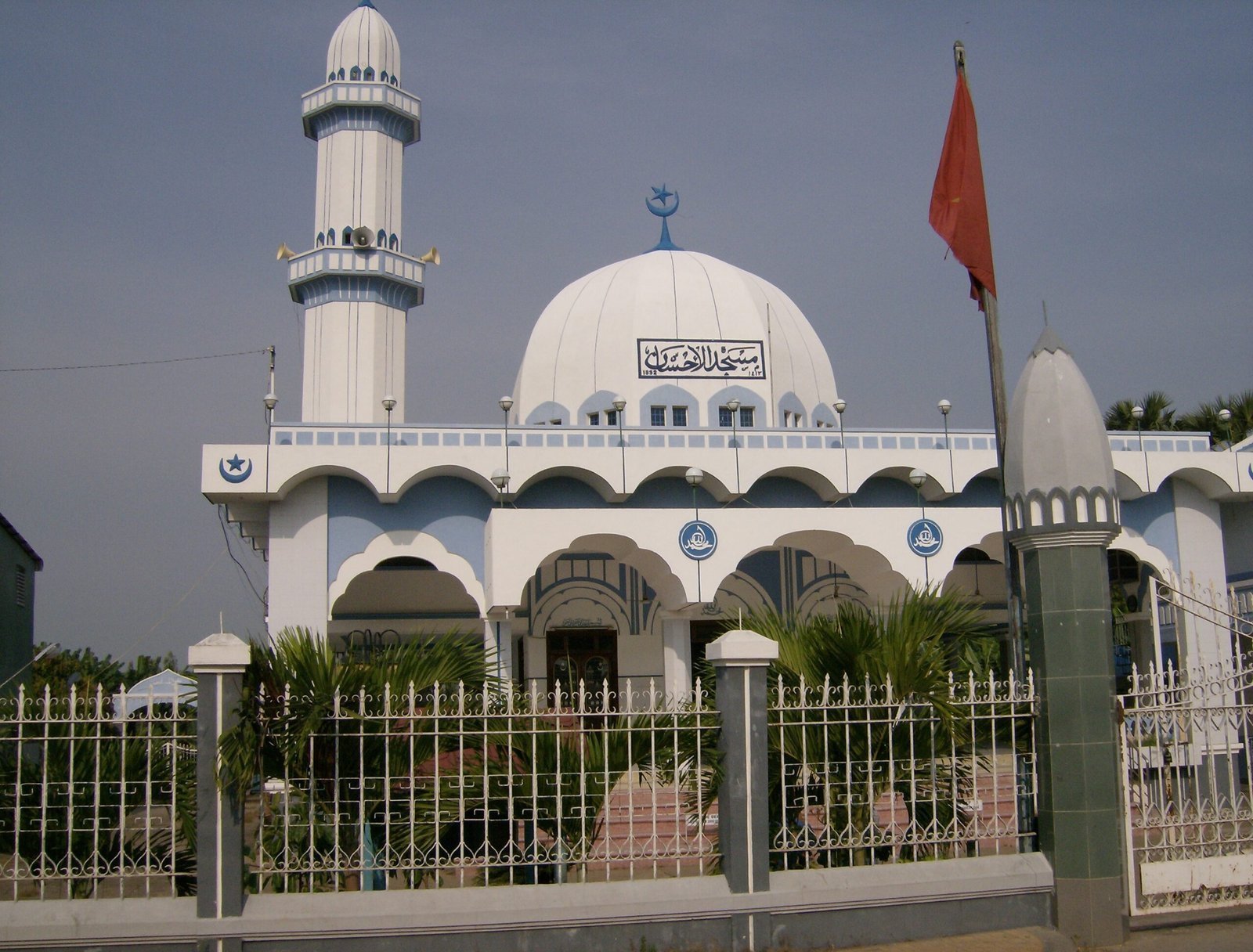 A white mosque with a dome and a minaret stands near Chau Doc in Vietnam.