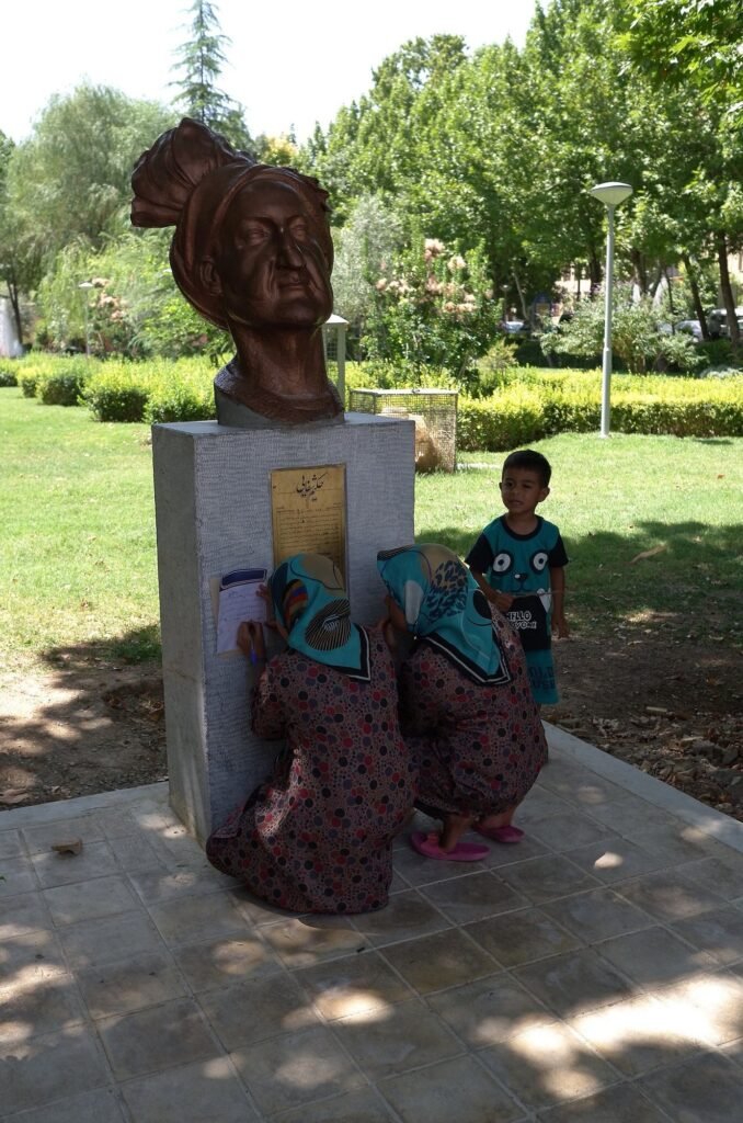 Bronze bust in the Chehel Sotoun garden with women and a child