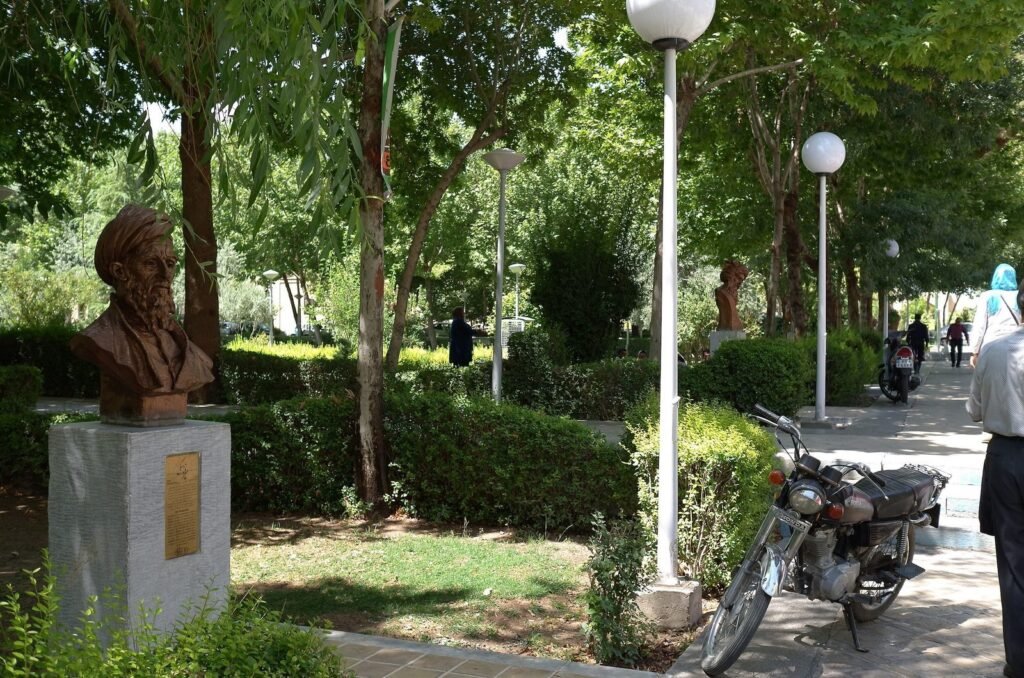 Bronze bust by a path with lamps in the Chehel Sotoun garden