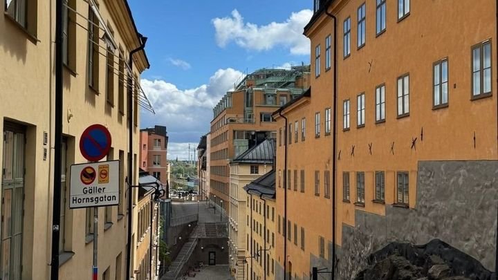 A cobblestone street with yellow houses on Södermalm, Stockholm, photographed by Zayera Khan