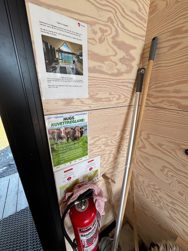 Fire extinguisher, a broom and notices in the entrance of Dagsturhytta