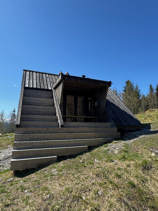 Wooden steps up to the entrance of Dagsturhytta, built into the hillside
