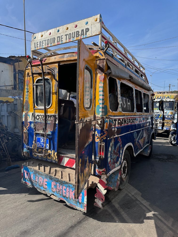 A painted minibus with an open back door stands in Dakar.