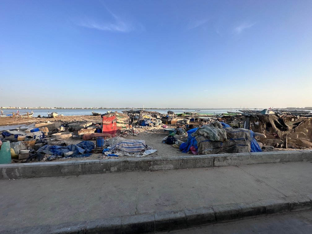 Fishing nets and gear lie on the shore at a fishing area in Dakar.
