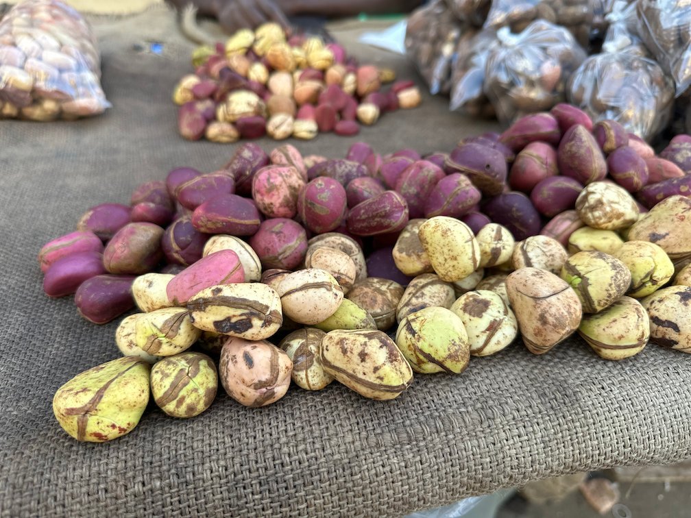 Red and white kola nuts lie on a cloth at a market stall in Dakar.