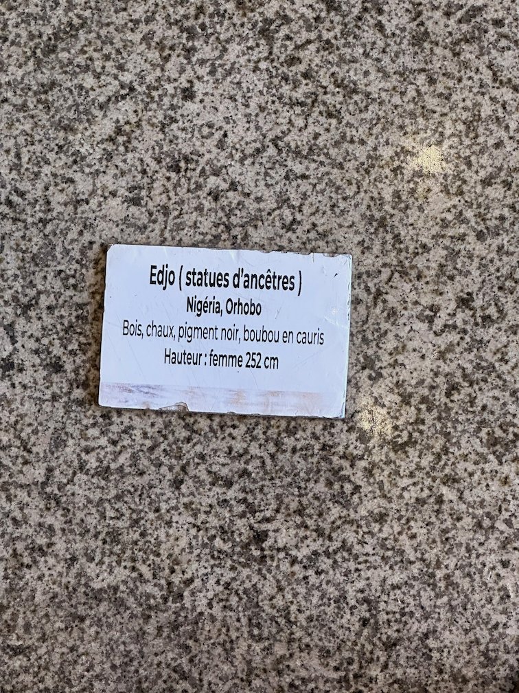 A small label names an ancestor statue from Nigeria in a Dakar museum.