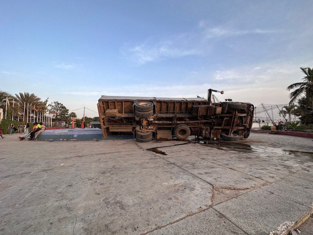 An overturned truck lies on a demolition site by the sea in Dakar.