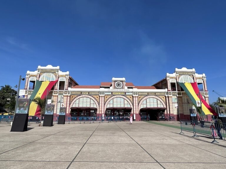 The old railway station in Dakar has arched windows and large Senegal flags on the front.