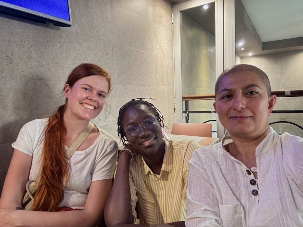 Zayera Khan takes a selfie with two young women in a cafe in Dakar.