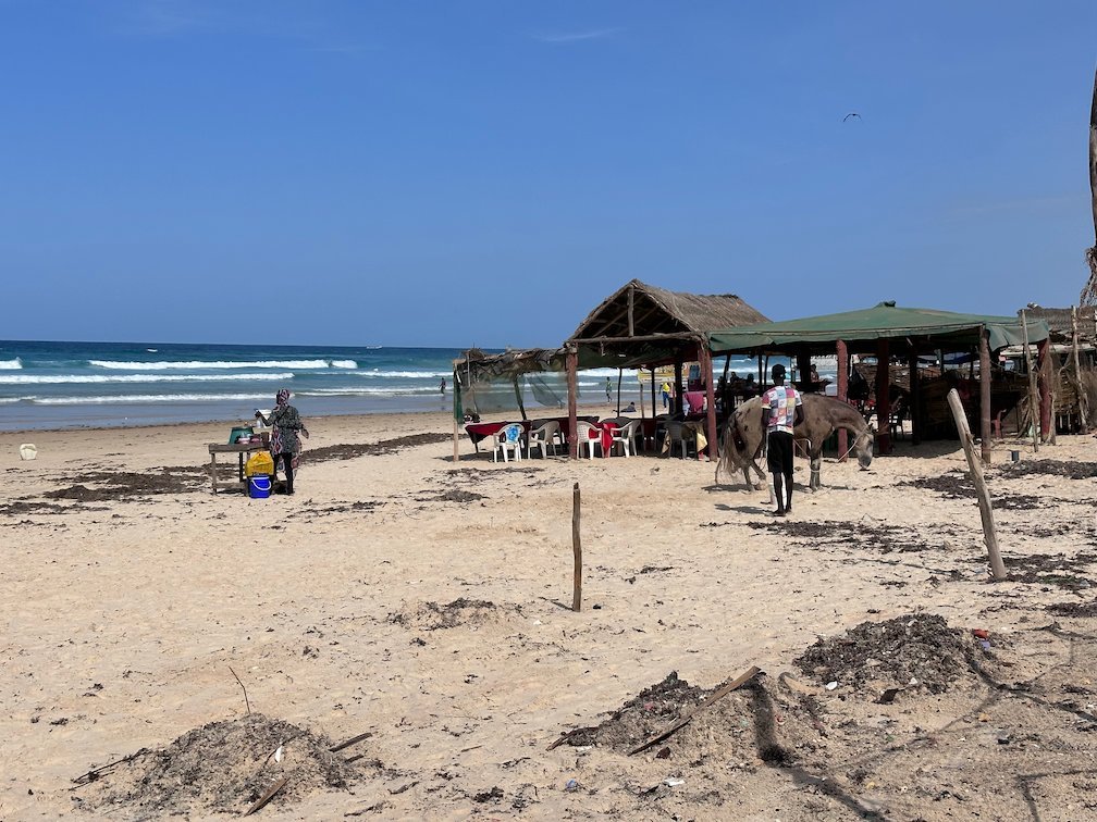 Beach huts with straw roofs stand on the sand of Yoff beach in Dakar.