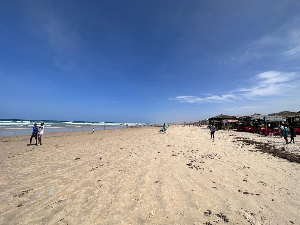 People walk on the long sandy Yoff beach in Dakar.