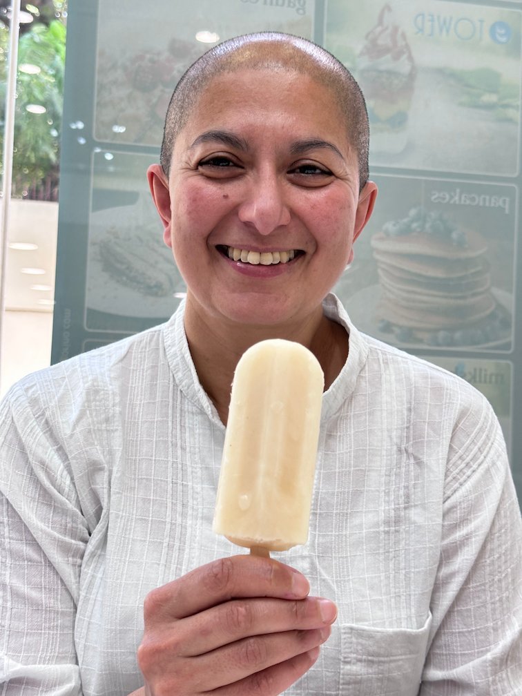 Zayera Khan smiles and holds an ice cream on a stick in Dakar.