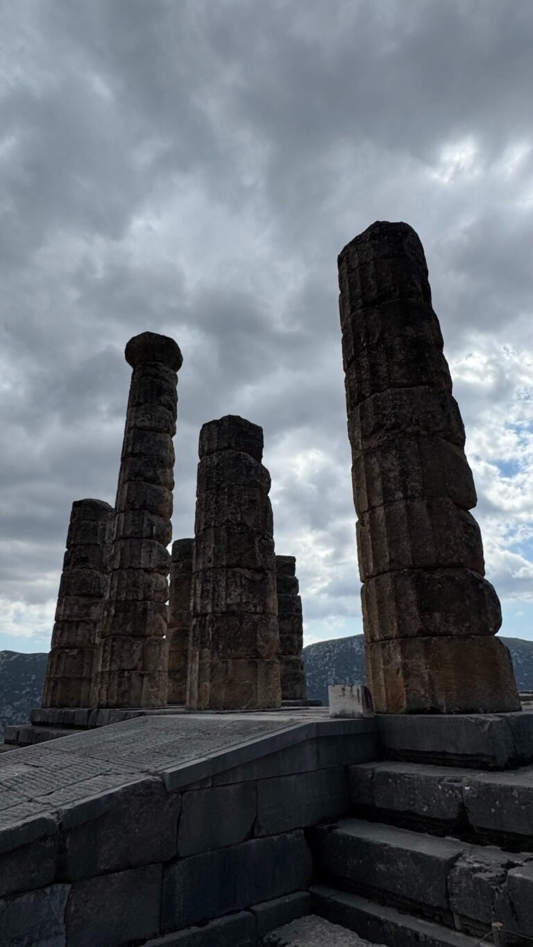 Standing columns of the Temple of Apollo at Delphi under a cloudy sky
