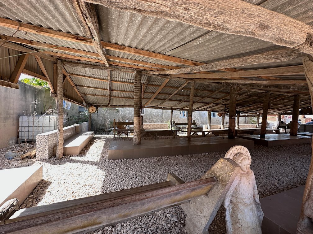 A white statue of the Virgin Mary stands under a shelter in Fadiouth.