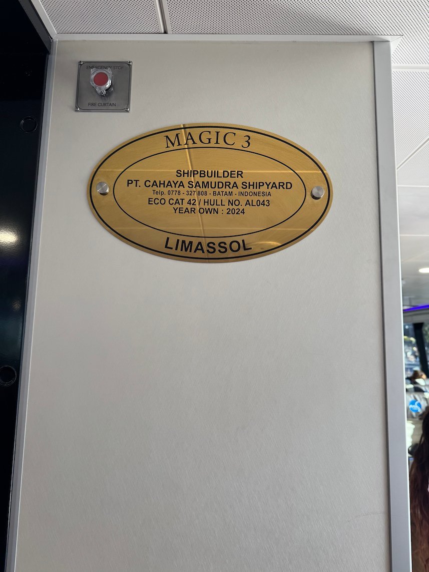 Brass plaque of the shipbuilder on a white wall inside the fast ferry