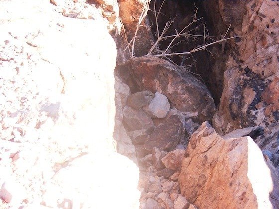 Bright sun lights a crack in reddish rock at the edge of Fish River Canyon, Namibia.