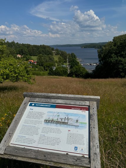 Information sign on Fjärås Bräcka with a view down to Lake Lygnern and wooded hills