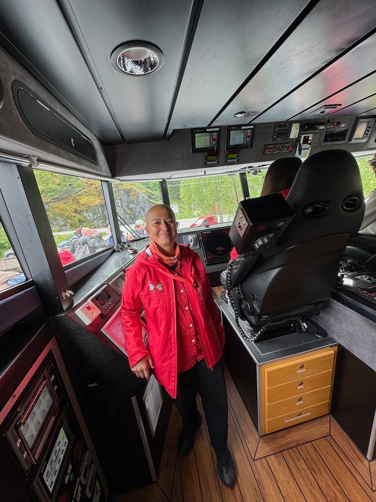 Zayera Khan in a red jacket on the bridge of the fjord boat