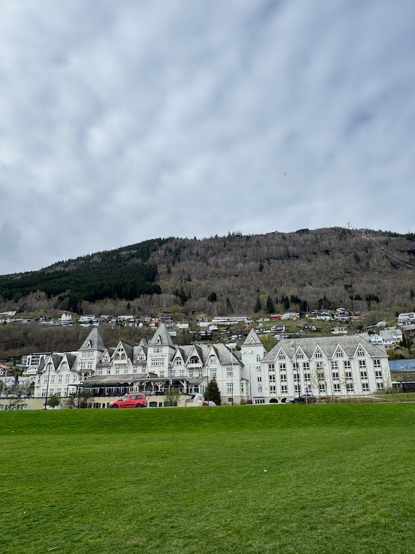 Fleischer’s Hotel in Voss, a large white wooden hotel, seen across a green field