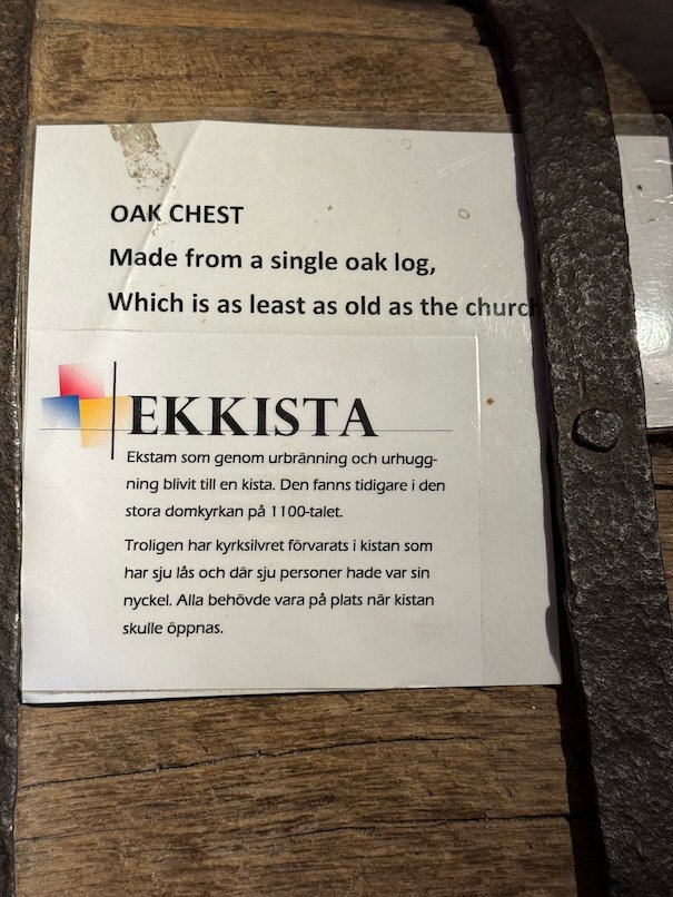 Sign that says the oak chest is made from a single oak log and is as old as the church