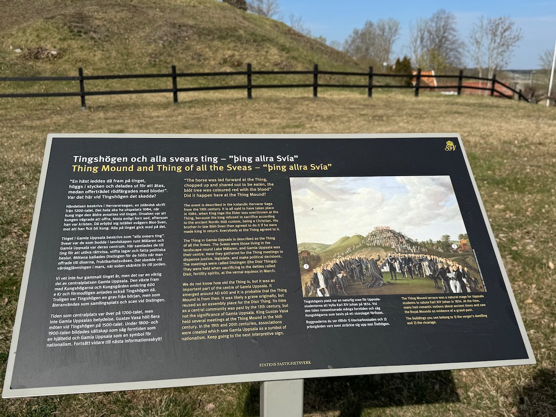Information sign about the Thing Mound and the Thing of all the Swedes, with a mound and fence behind