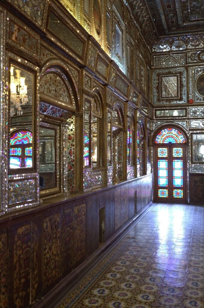 Hall with mirror work and a stained glass door at Golestan Palace