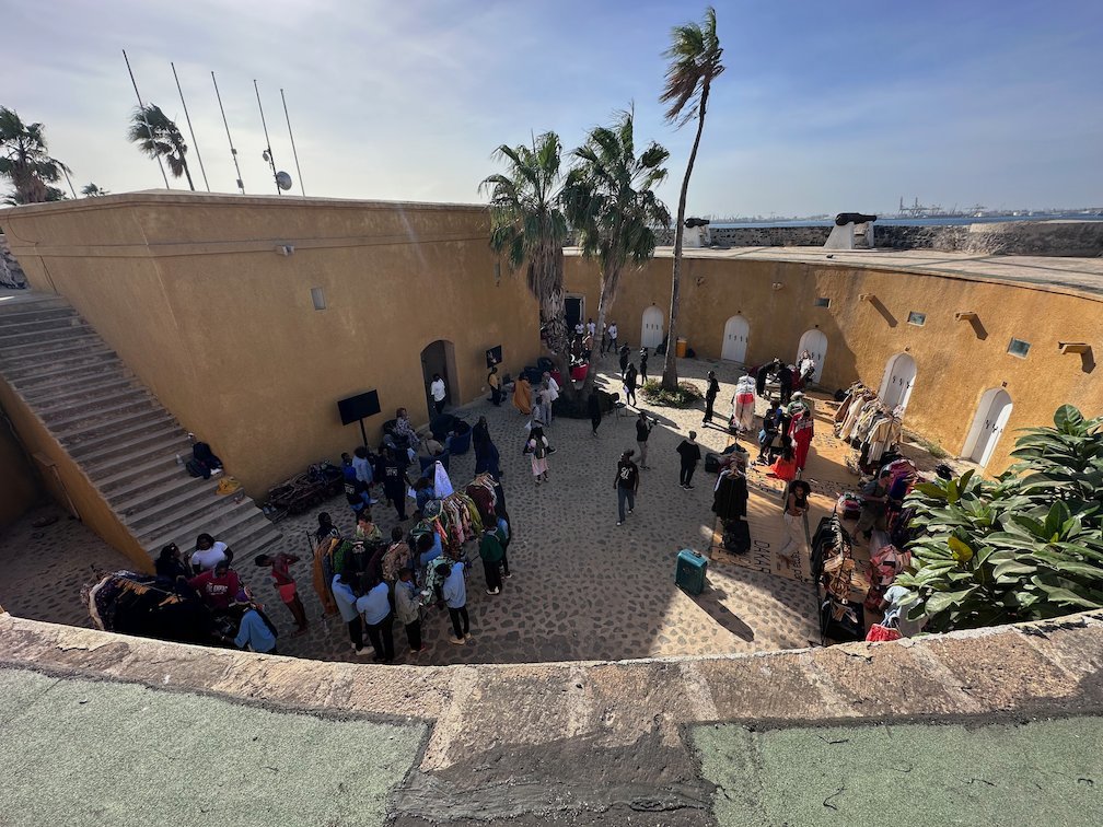 People gather in the courtyard of an old fort on Goree Island for an event.