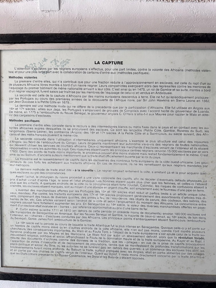 A text panel about the capture of enslaved people hangs in a Goree Island museum.