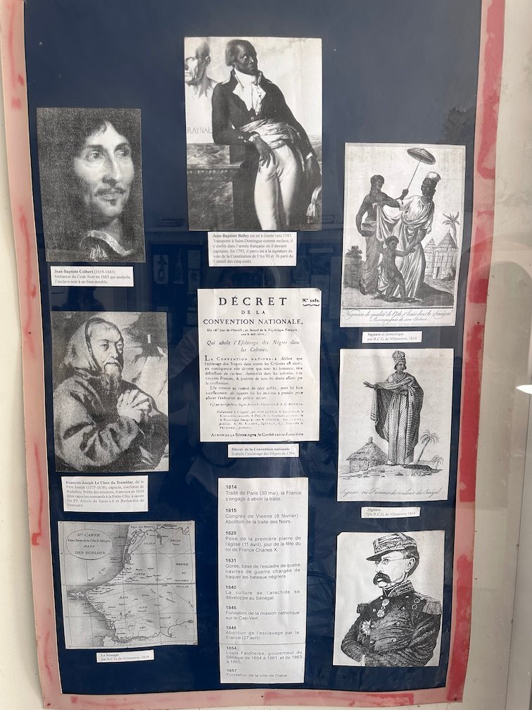 A museum board shows a decree and old portraits on Goree Island.