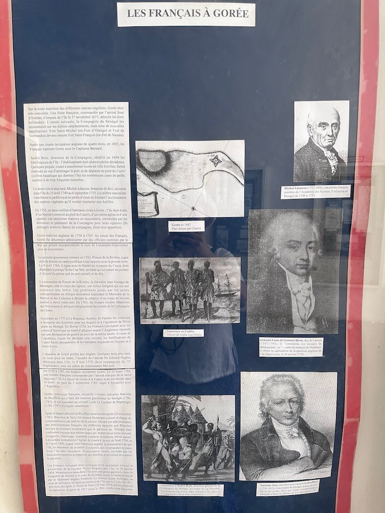 A museum board shows texts and portraits about the French on Goree Island.