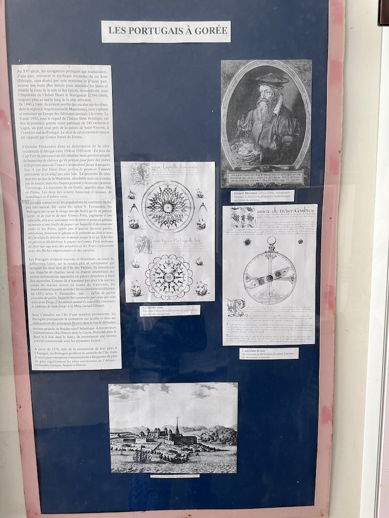 A museum board shows texts and old pictures about the Portuguese on Goree Island.
