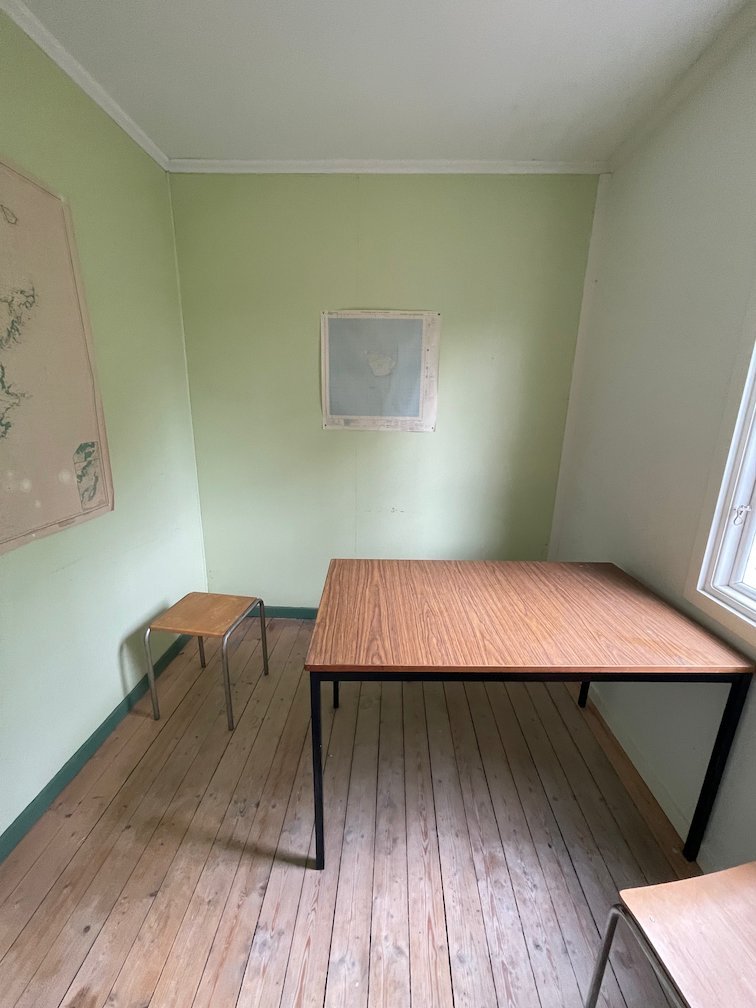 Rum i raststugan med ett bord och pallar