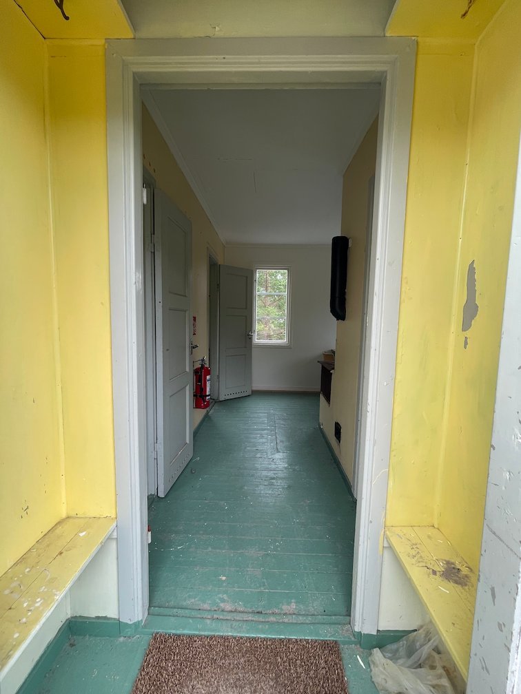 Hall i Tärnuddens raststuga med gula väggar och grönt golv