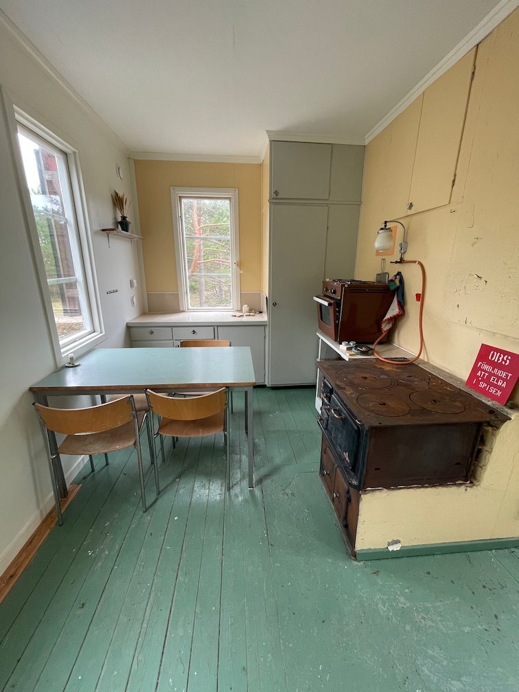 Kök i raststugan med vedspis, bord och stolar