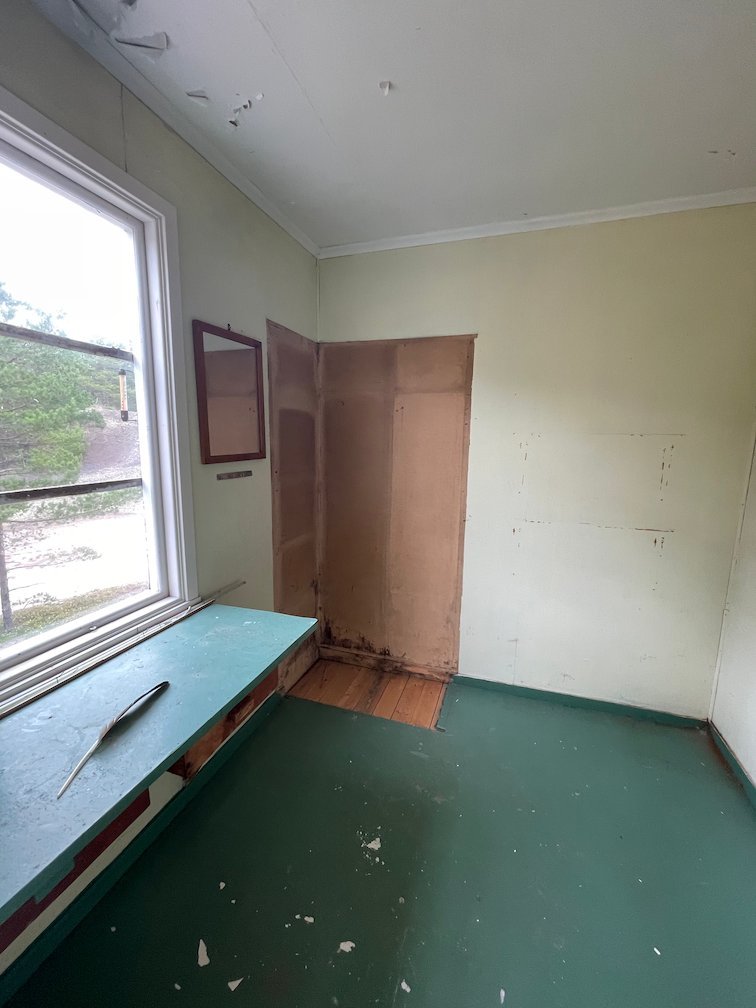 Rum i raststugan med en grön bänk under fönstret