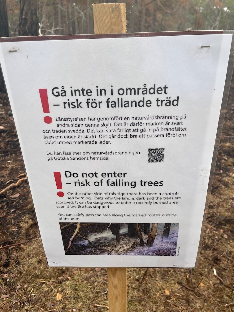 Skylt Gå inte in i området, risk för fallande träd, efter en naturvårdsbränning