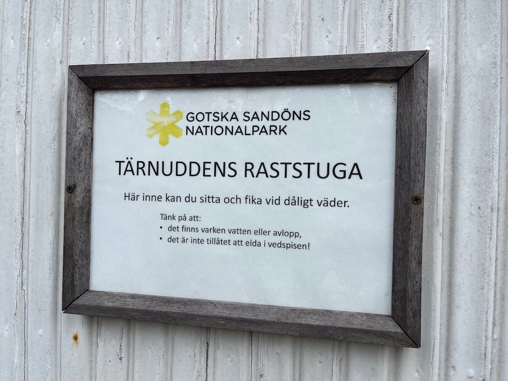 Skylt Tärnuddens raststuga, här kan du sitta och fika vid dåligt väder