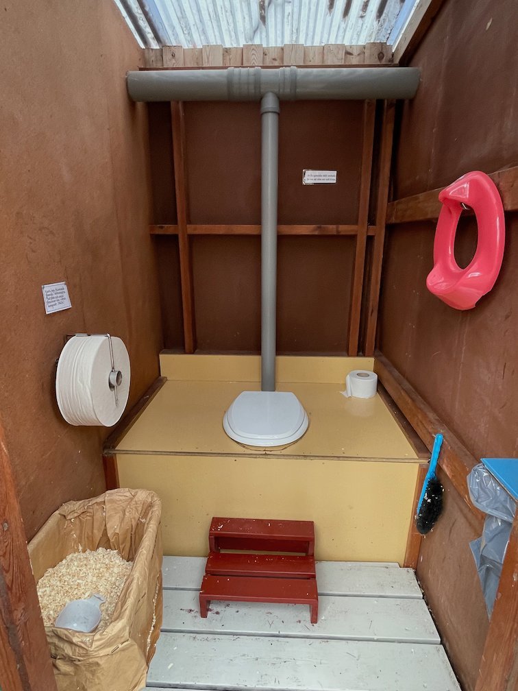 Insidan av en torrtoalett med ströspån på Gotska Sandön
