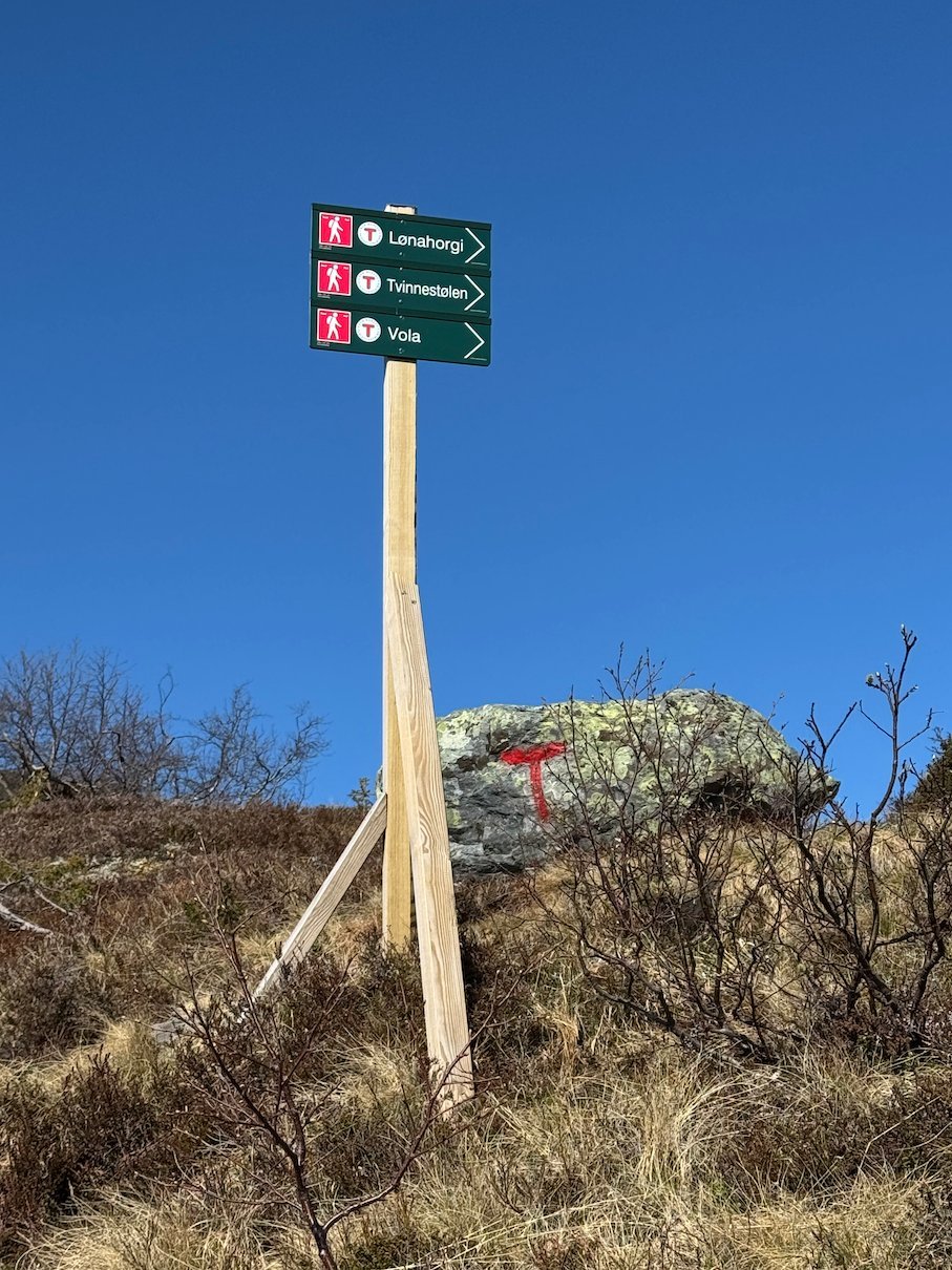 Green trail signs on a wooden post on the mountain near Hanguren