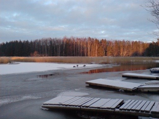 Frosty wooden jetty sections lie on the ice at sunset on Kadermo island near Hanko.