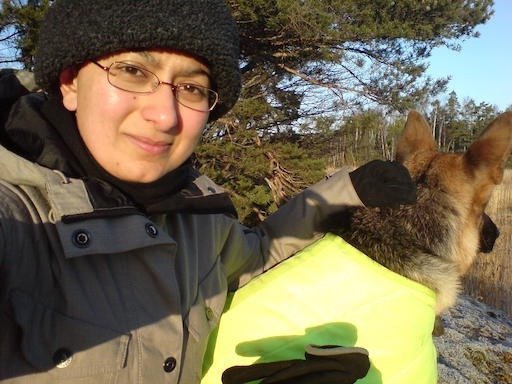 Zayera Khan takes a selfie with a dog in a yellow vest on Kadermo island near Hanko.