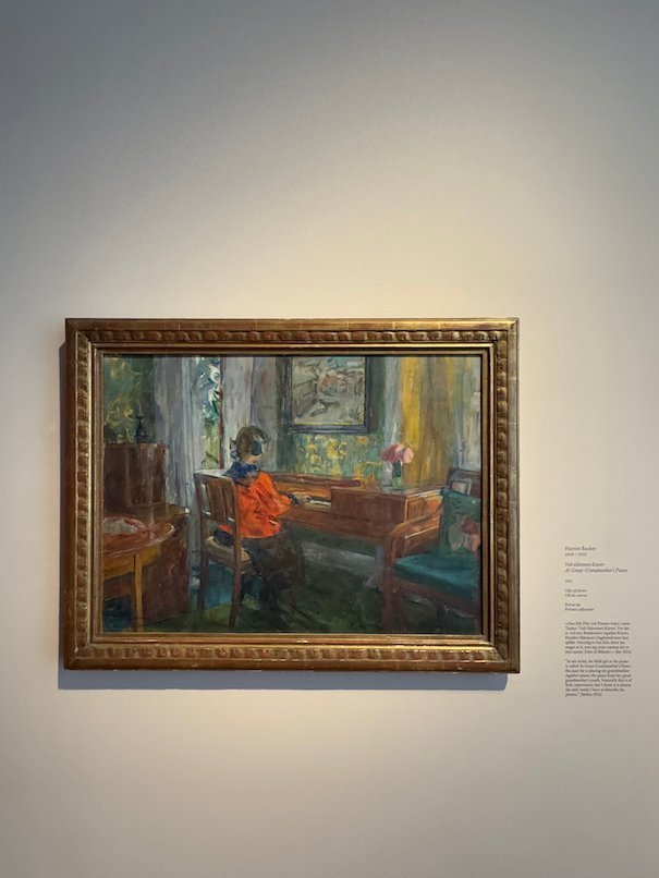 Painting by Harriet Backer of a girl in red by a window