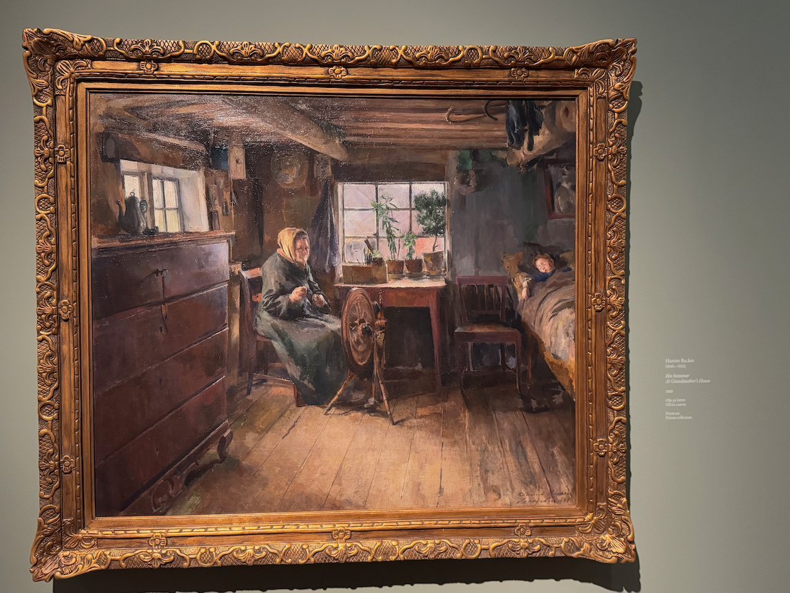 Painting by Harriet Backer of a farmhouse room with a woman at a spinning wheel by the window