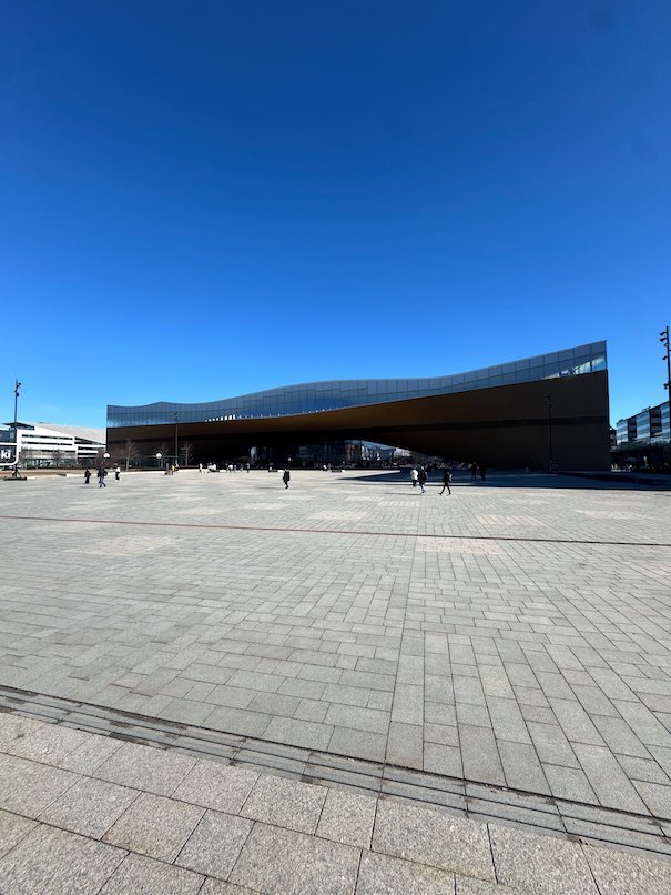 The curved wooden facade of Oodi library stands at the end of Kansalaistori square in Helsinki.