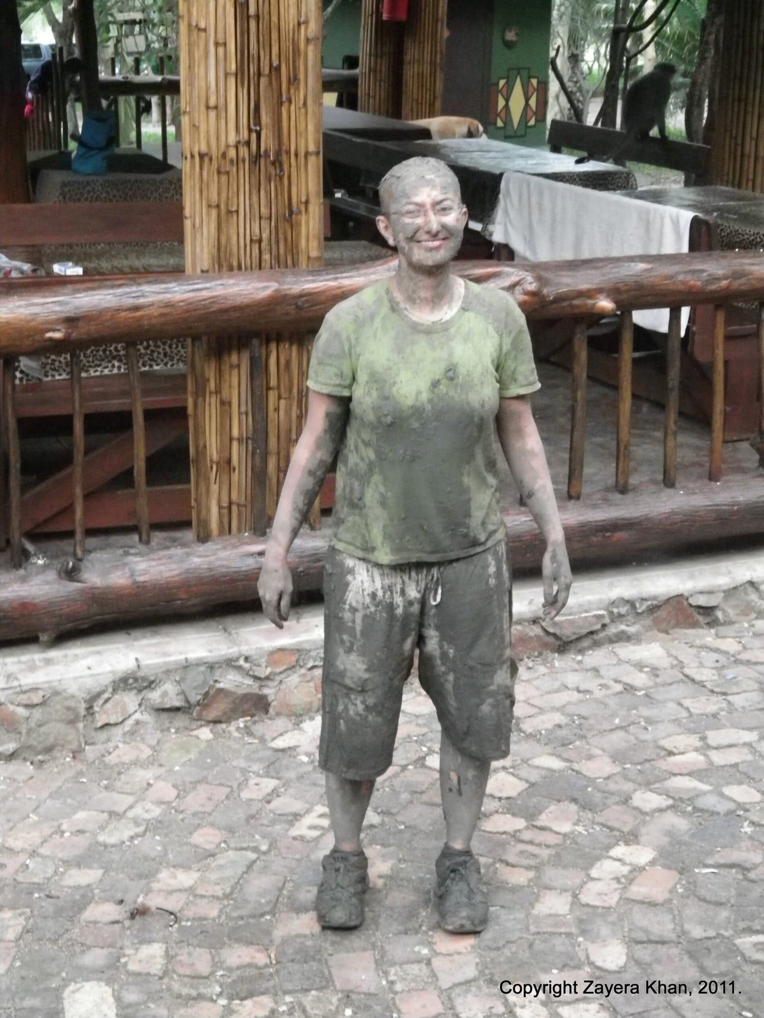 Zayera Khan stands covered in grey mud after field work at the camp near Hoedspruit.